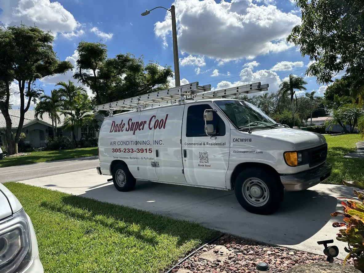 A Dade Super Cool Air Conditioning service van with a roof ladder rack parked in the driveway of a Miami home